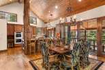 Step into luxury with this stunning dining room, featuring a rustic wooden ceiling and a grand chandelier.