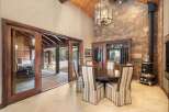 Step into luxury with this stunning dining room, featuring a beautiful stone accent wall and a grand chandelier.