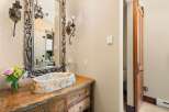 Step into luxury with this stunning bathroom! Featuring a unique stone sink and a beautifully crafted wooden vanity, this space exudes rustic elegance.
