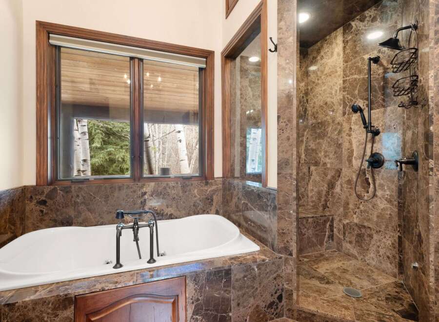 Indulge in luxury within this stunning bathroom, featuring a sleek soaking tub and a separate walk-in shower.