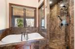 Indulge in luxury within this stunning bathroom, featuring a sleek soaking tub and a separate walk-in shower.