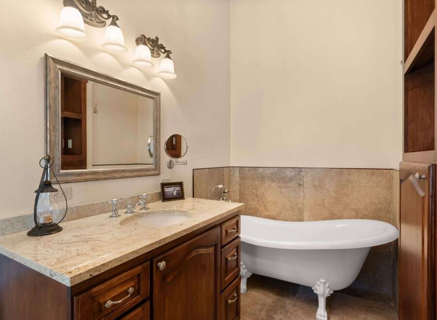 Step into luxury with this stunning bathroom featuring a clawfoot tub and elegant vanity.