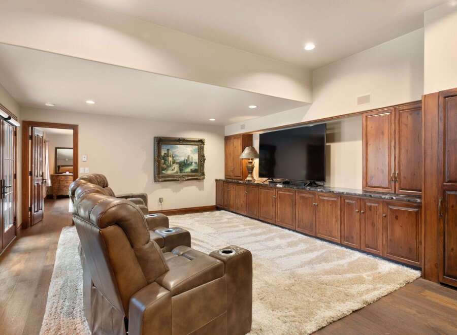 Step into luxury with this stunning home theater! Featuring a large flat-screen TV, comfortable seating, and a plush rug, this space is perfect for movie nights.