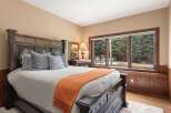 This luxurious bedroom boasts a stunning view of the surrounding landscape through its large windows.