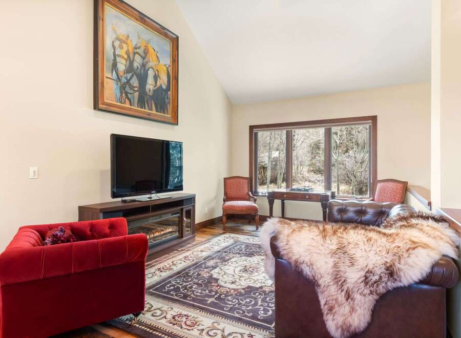 Step into luxury with this stunning living room, featuring a cozy fireplace and a large flat-screen TV, perfect for relaxing evenings.