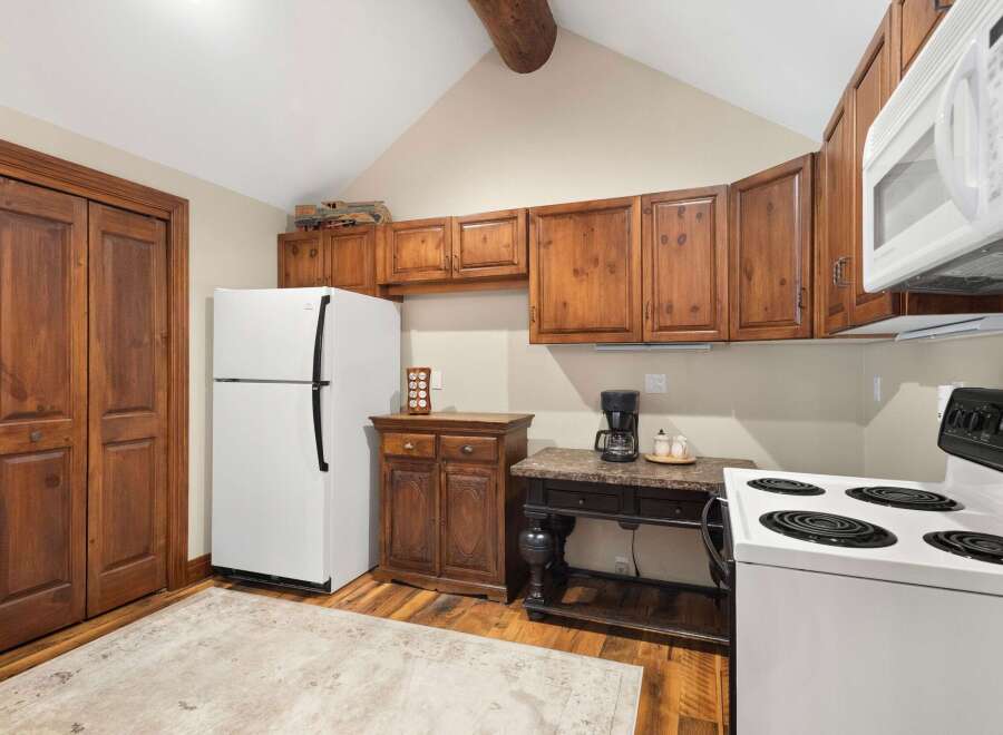 Step into this charming kitchen, featuring warm wooden cabinetry and a classic white refrigerator.