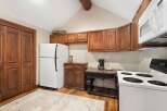 Step into this charming kitchen, featuring warm wooden cabinetry and a classic white refrigerator.
