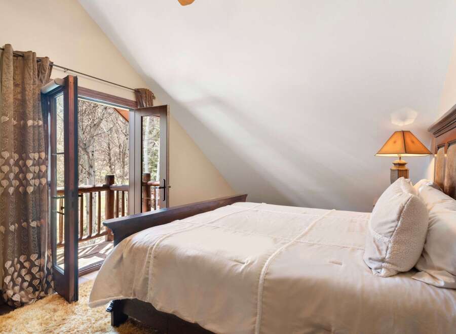 Experience the tranquility of this stunning bedroom, featuring a cozy bed and a private balcony.