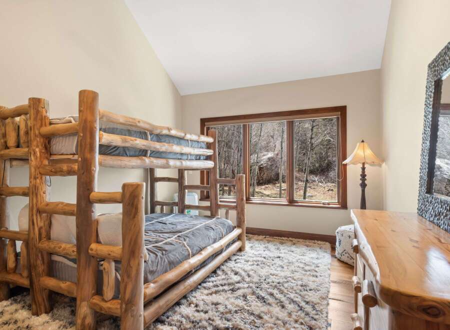 This cozy bedroom features a rustic bunk bed, perfect for a vacation home or a kid's room.