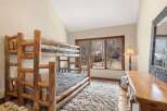 This cozy bedroom features a rustic bunk bed, perfect for a vacation home or a kid's room.