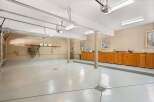 This spacious garage offers ample room for vehicles and storage, featuring a sleek, polished floor.