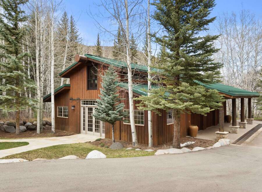 Nestled amidst a serene landscape, this stunning property boasts a beautiful wooden exterior and a charming green roof.