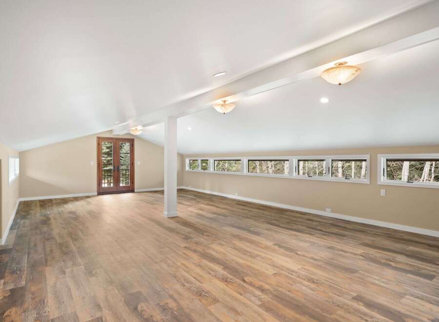 Step into this stunning, light-filled space featuring a vaulted ceiling and beautiful wood flooring.