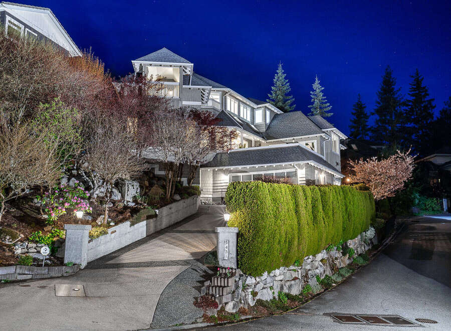 This stunning property boasts a beautifully designed exterior with a well-manicured lawn and lush landscaping.