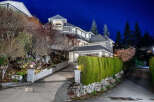 This stunning property boasts a beautifully designed exterior with a well-manicured lawn and lush landscaping.