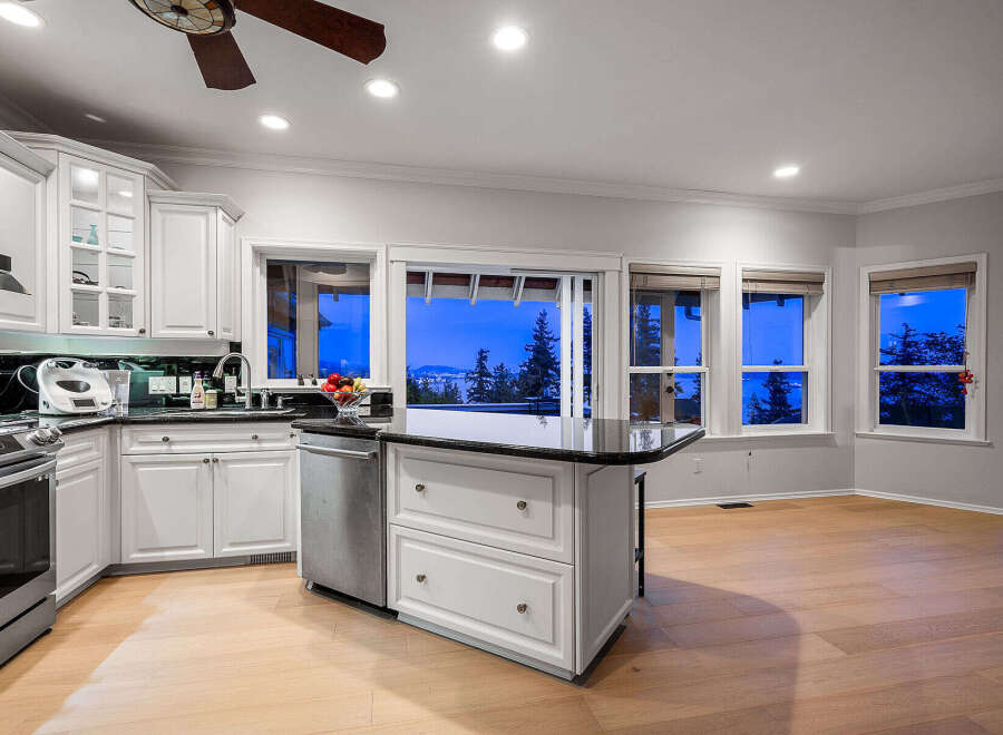This stunning kitchen boasts a modern design with sleek white cabinetry and a contrasting black countertop.