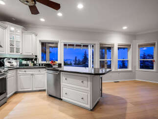 This stunning kitchen boasts a modern design with sleek white cabinetry and a contrasting black countertop.