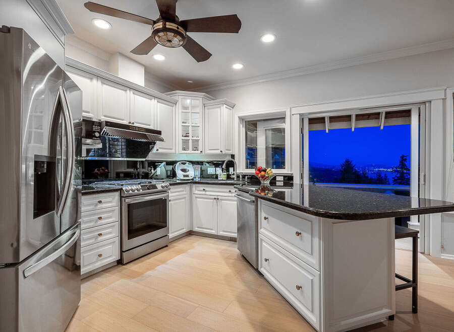 This stunning kitchen boasts a modern design with sleek white cabinetry and stainless steel appliances.