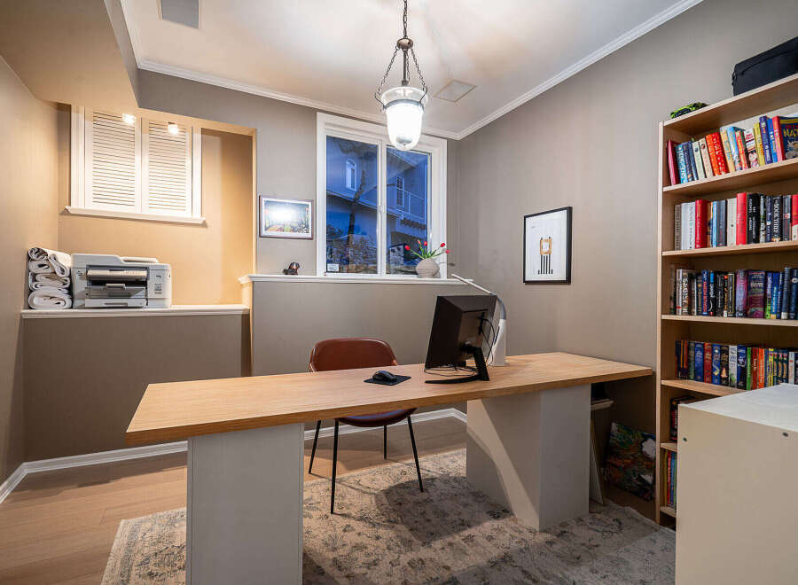 This home office offers a stylish and functional workspace with a modern desk and ample natural light.
