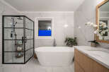 Step into luxury with this stunning bathroom! Featuring a sleek, modern design, this space boasts a beautiful freestanding tub, a glass-enclosed shower, and elegant marble-look tile.