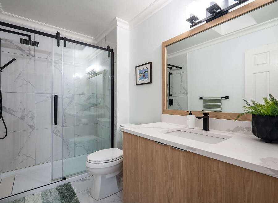 Step into a beautifully designed bathroom featuring a modern glass shower enclosure and sleek black fixtures.