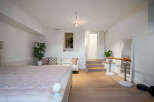 This bright and airy bedroom boasts a unique layout with a cozy seating area and a dedicated ballet barre space.