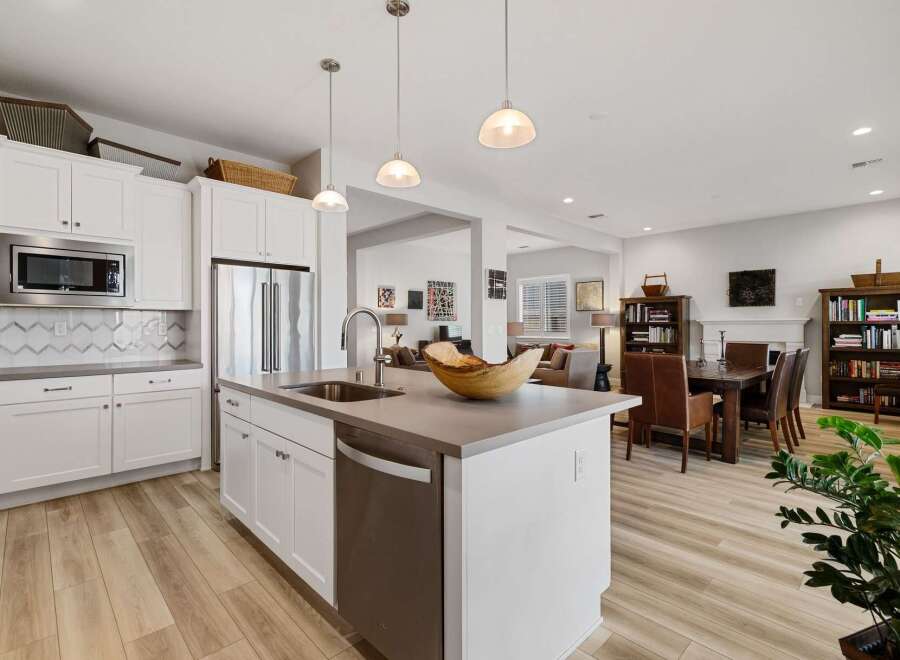 This stunning kitchen boasts modern design with sleek white cabinetry, stainless steel appliances, and a spacious island perfect for meal prep and entertaining.