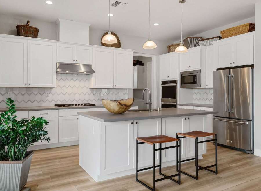 This stunning kitchen boasts a modern design with sleek white cabinetry and a spacious island, perfect for both cooking and entertaining.