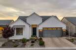 This stunning modern farmhouse boasts a beautiful exterior with a white facade and a stylish gray garage door.
