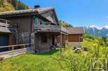 Discover a charming wooden chalet nestled in a picturesque mountain setting.