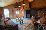 Experience the charm of this cozy living room, featuring a rustic wooden ceiling and walls, creating a warm and inviting atmosphere.