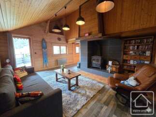 Experience the charm of this cozy living room, featuring a rustic wooden ceiling and walls, creating a warm and inviting atmosphere.