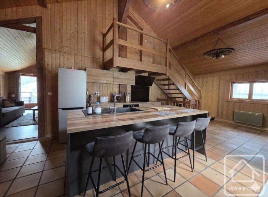 This stunning property boasts a beautifully designed kitchen with a modern island and stylish bar stools, perfect for entertaining.