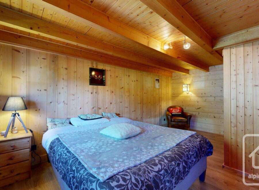 This cozy bedroom features a rustic wooden interior, creating a warm and inviting atmosphere.