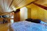 Discover the charm of this cozy bedroom featuring a unique wooden ceiling and walls, creating a warm and inviting atmosphere.