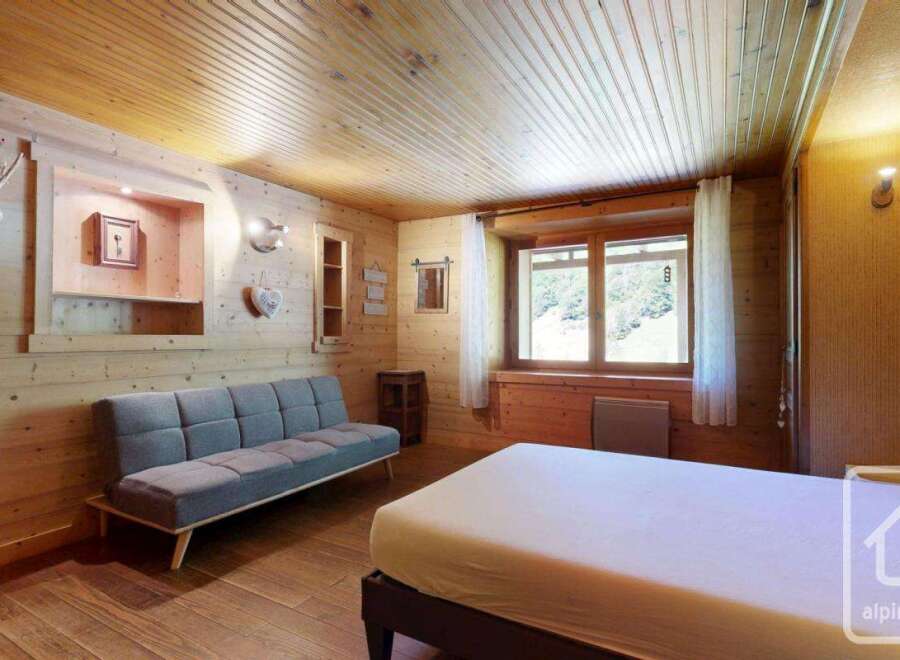 Discover the charm of this cozy mountain retreat, featuring a warm wooden interior and a comfortable living space.