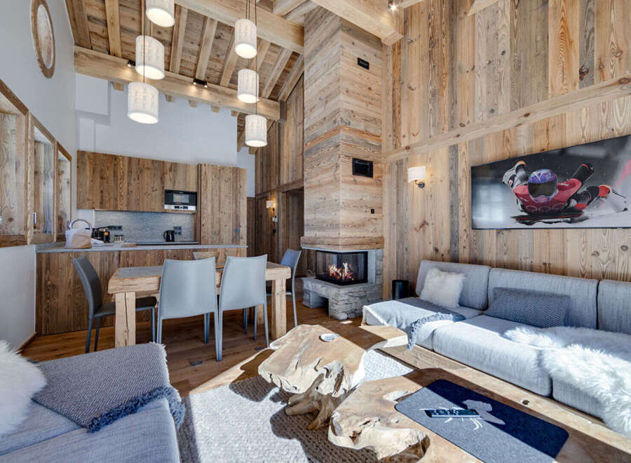 Experience luxury living in this stunning chalet, featuring a cozy fireplace and a modern kitchen.