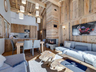 Experience luxury living in this stunning chalet, featuring a cozy fireplace and a modern kitchen.