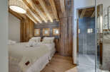 Experience rustic elegance in this stunning bedroom, featuring exposed wooden beams and a cozy ambiance.