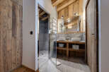 Step into luxury with this stunning bathroom featuring a modern glass shower and rustic wooden accents.