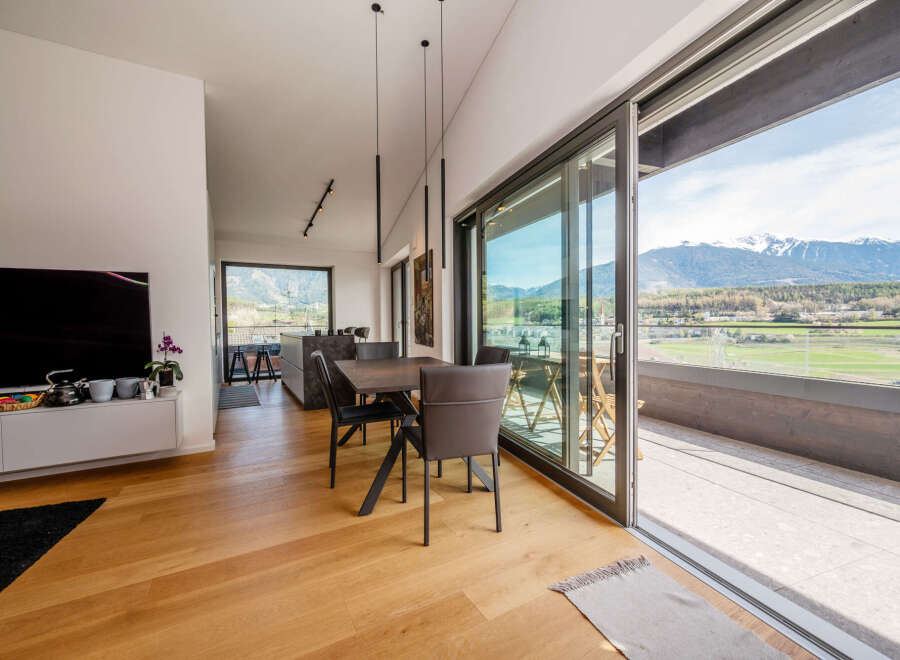 Experience luxury living in this stunning property featuring a modern dining area with sleek furniture and elegant lighting.