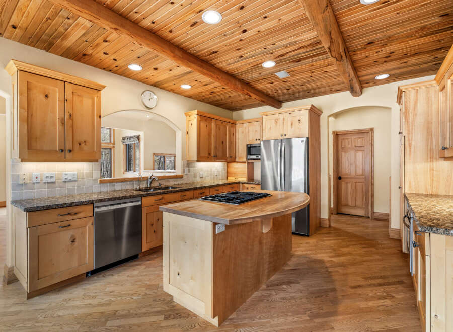 This stunning kitchen boasts a warm and inviting atmosphere with its wooden ceiling and cabinetry.