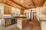 This stunning kitchen boasts a warm and inviting atmosphere with its wooden ceiling and cabinetry.