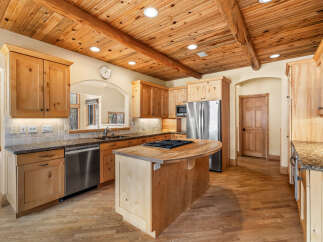 This stunning kitchen boasts a warm and inviting atmosphere with its wooden ceiling and cabinetry.
