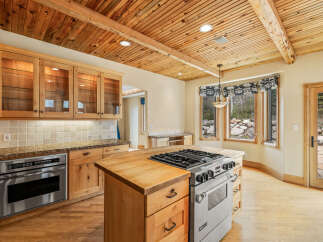 This stunning kitchen boasts a warm and inviting atmosphere with its wooden ceiling and cabinetry.