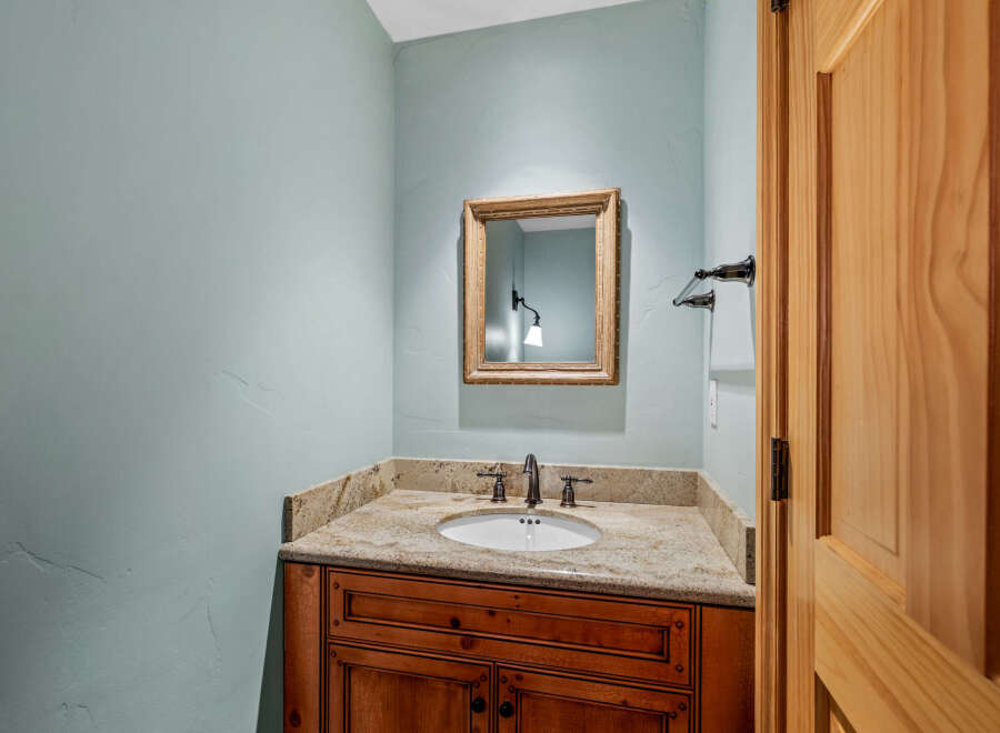 This stunning bathroom boasts a beautiful vanity with a granite countertop, offering both style and functionality.