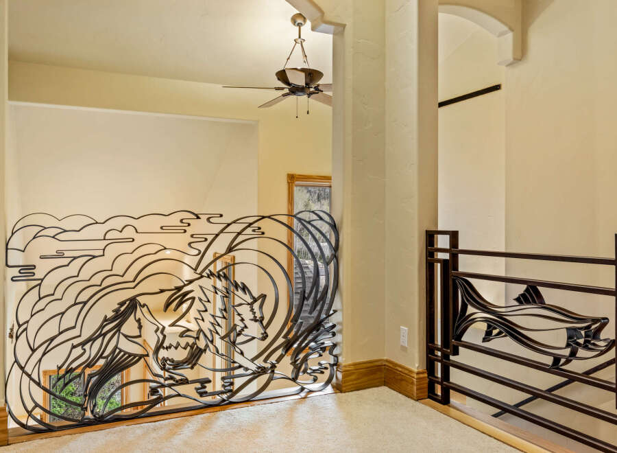 This stunning property boasts a unique wrought iron railing with a wolf design, adding a touch of artistry to the interior.