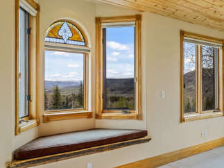 This stunning property boasts a unique architectural design with expansive windows that frame breathtaking mountain views.