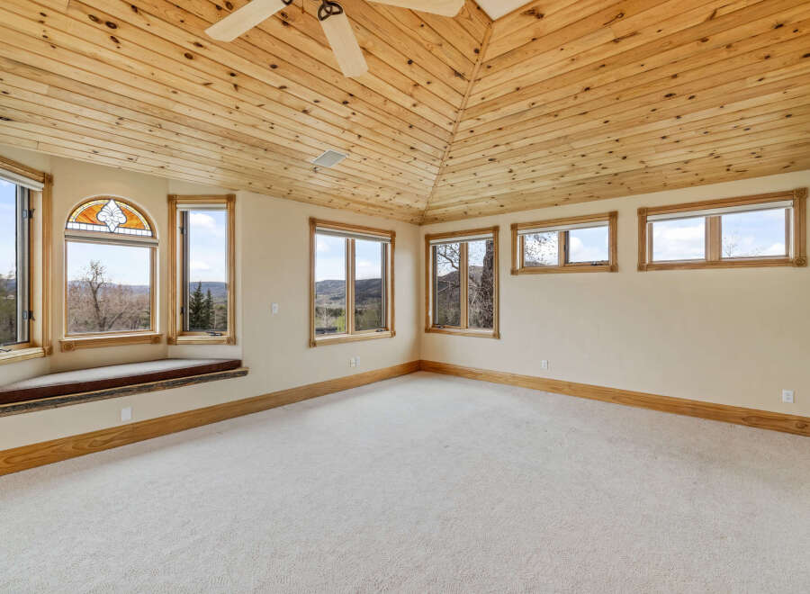 This stunning room boasts a unique wooden ceiling and ample natural light, creating a warm and inviting atmosphere.