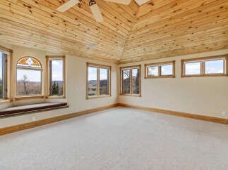 This stunning room boasts a unique wooden ceiling and ample natural light, creating a warm and inviting atmosphere.